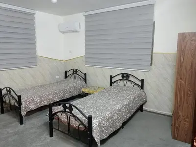two beds in a room with two windows at Bait al salam in Um Qeis