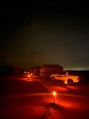 a white truck parked in a parking lot at night at Wadirum sunset camp in Wadi Rum