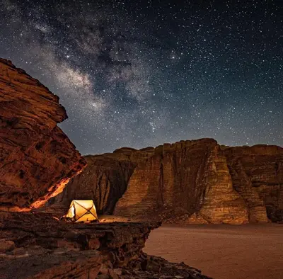 a lit up tent in the desert under a night sky at Wadirum sunset camp in Wadi Rum