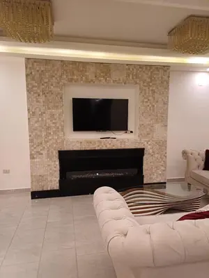 a living room with a couch and a television on a fireplace at Apartment in Khalda in Amman