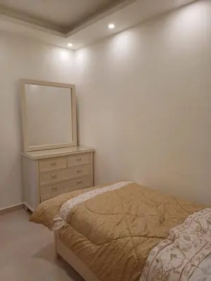 a bedroom with a bed and a dresser with a mirror at Apartment in Khalda in Amman