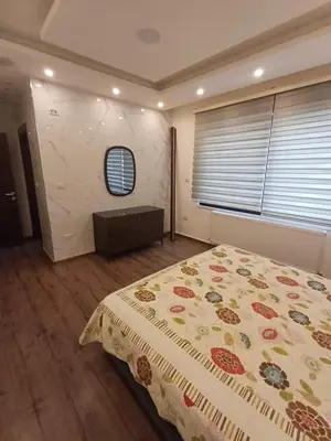 a bedroom with a large bed and a window at Apartment in Khalda in Amman