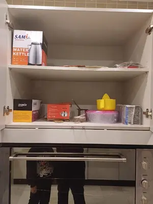 a shelf in a refrigerator with books and other items at Apartment in Khalda in Amman