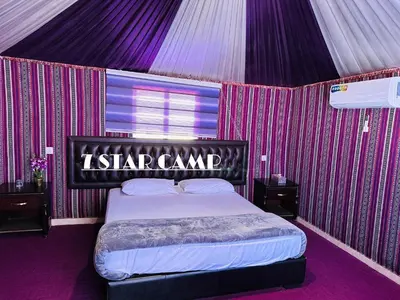 a tent with a bed with a sign on it at 7star camp in Wadi Rum