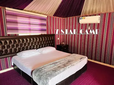 a bedroom with a bed with a red wall at 7star camp in Wadi Rum