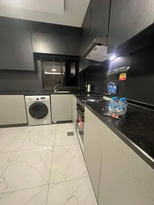 a kitchen with a black and white counter top at Cozy and Tranquil Rooftop Near Al Services 23 in Amman