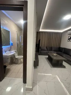 a living room with a couch and a bathroom at Cozy and Tranquil Rooftop Near Al Services 23 in Amman