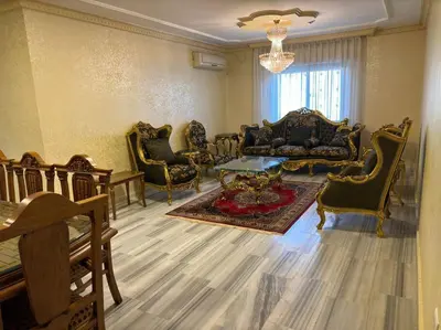 a large living room with chairs and a table at Zahrat AL-Mada'in apartment in Irbid