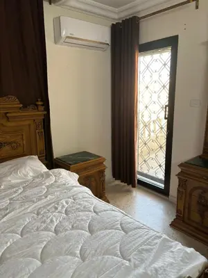 a bedroom with a large bed and a window at Zahrat AL-Mada'in apartment in Irbid