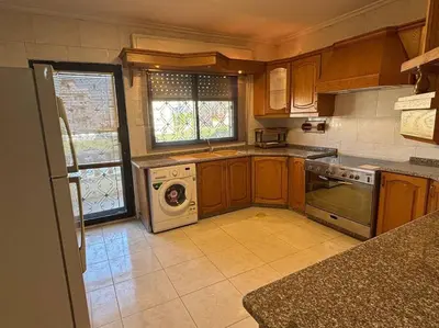 a kitchen with a stove and a dishwasher at Zahrat AL-Mada'in apartment in Irbid