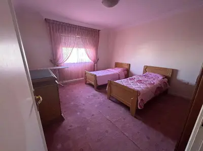 a bedroom with two beds and a window at Zahrat AL-Mada'in apartment in Irbid