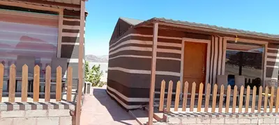 a house with a wooden fence in front of it at Rum Honeymoon Camp in Wadi Rum