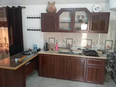 a kitchen with wooden cabinets and a sink at Jerash Roman Gate studio chalet ستوديو شاليه بوابة جرش الرومانيه الشماليه in Jerash