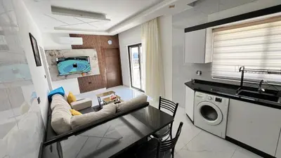 a kitchen and living room with a couch and a sink at شقة بثلاث غرف نوم الجاردنز عمو سامي in Amman