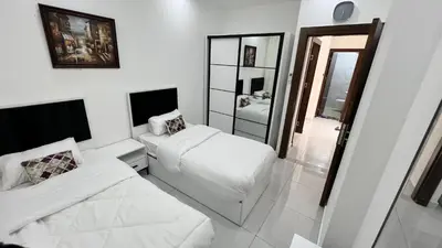 a white room with two beds and a mirror at شقة بثلاث غرف نوم الجاردنز عمو سامي in Amman