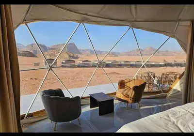 a bedroom with a view of the desert from a tent at Wadi rum stay & tours in Wadi Rum