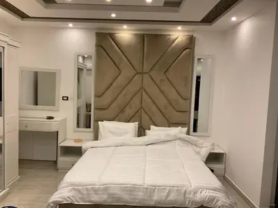 a bedroom with a large white bed and two mirrors at استديو فندقي راقي in Amman