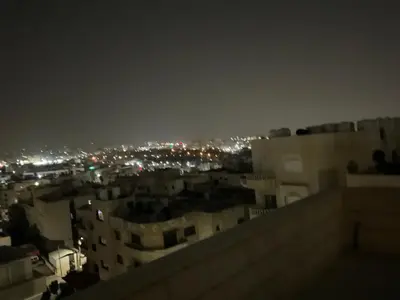 a view of a city at night with lights at استديو فندقي راقي in Amman