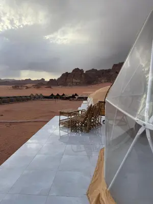 a view of a desert with tables and tents at Desert Oasis Lodge in Wadi Rum in Disah