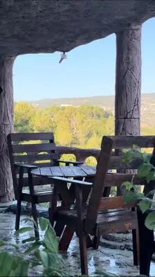 a wooden picnic table with a view of a field at منتزه واكواخ كركوش in Ajloun