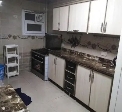 a kitchen with white cabinets and a stove top oven at Samira House in Amman
