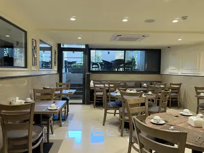 a restaurant with wooden tables and chairs and windows at Saraya Abdeen Hotel in Aqaba