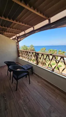 a balcony with two chairs and a view of the ocean at Saraya Abdeen Hotel in Aqaba