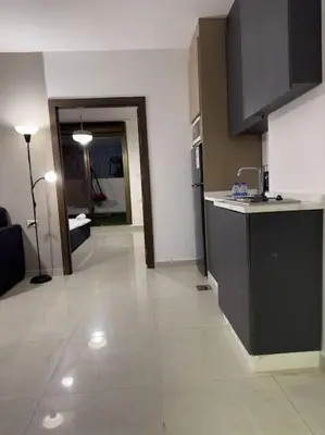 a room with a kitchen with a counter and a hallway at Stylish Luxe Apartment F/R 0001 in Amman