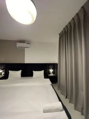 a bedroom with a large white bed and a large light at Stylish Luxe Apartment F/R 0001 in Amman