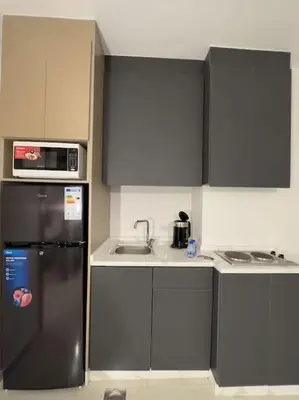 a kitchen with a black refrigerator and a sink at Stylish Luxe Apartment F/R 0001 in Amman