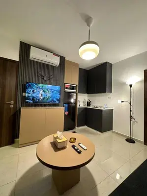 a living room with a table and a kitchen at Stylish Luxe Apartment F/R 0002 in Amman
