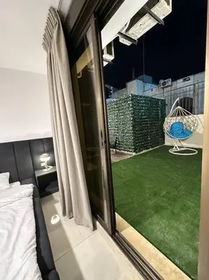 a bedroom with a balcony with a green lawn at Stylish Luxe Apartment F/R 0002 in Amman