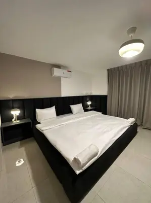 a bedroom with a large white bed with two lamps at Stylish Luxe Apartment F/R 0004 in Amman