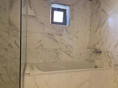 a white tub in a bathroom with a window at Horizon Loft in Bilāl