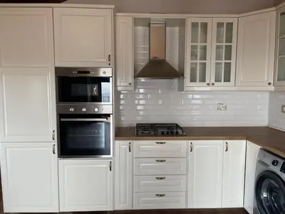 a kitchen with white cabinets and a stove top oven at Horizon Loft in Bilāl