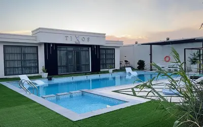 a swimming pool in front of a building at Tixos Farm in Irbid