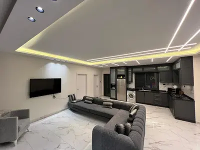 a large living room with a couch and a kitchen at Tixos Farm in Irbid