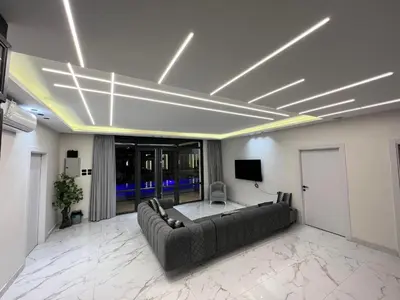 a living room with a couch and a tv on the ceiling at Tixos Farm in Irbid