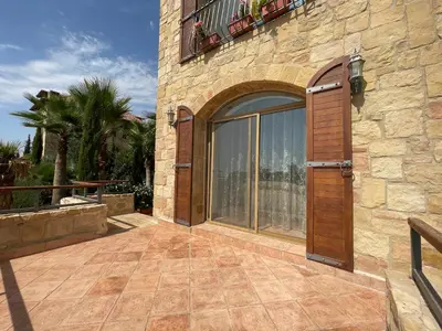 a stone building with a wooden door and a patio at Horizon1 in Amman
