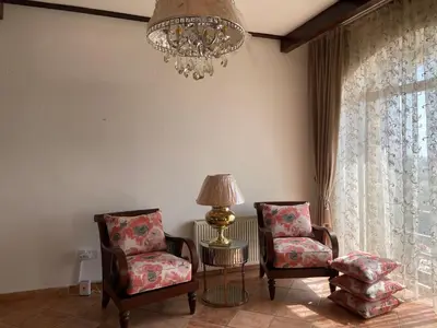 a living room with two chairs and a table and a chandelier at Horizon1 in Amman
