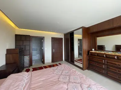 a bedroom with a large bed and a large mirror at Horizon1 in Amman