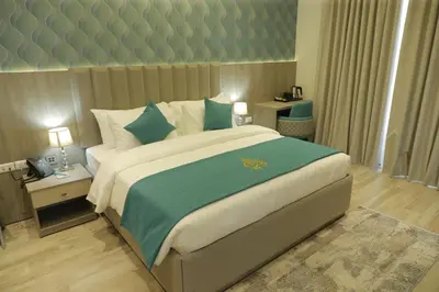 a bedroom with a large bed with a green blanket at Soho Midtown in Ash Shumaysānī