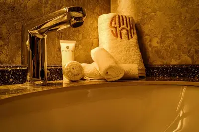 a bathroom with a bath tub with towels and a sink at Soho Midtown in Ash Shumaysānī