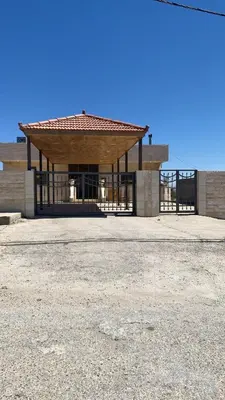 a building with a gate in the middle of a field at Laura's Stylish Villa in Madaba
