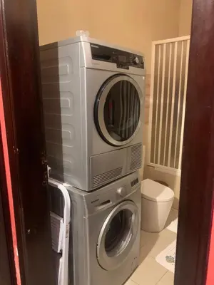 a washer and dryer sitting on top of a washing machine at Laura's Stylish Villa in Madaba