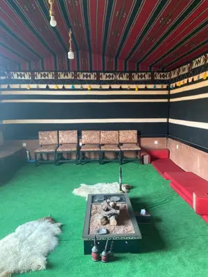 a room with a stage with chairs and a table at Omar Camp Wadi Rum in Disah