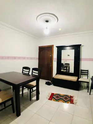 a dining room with a table and chairs and a mirror at Super modern comfortable apartment at the heart of historic Amman in Amman