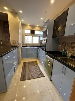 a large kitchen with white cabinets and a rug at Holy land in Amman