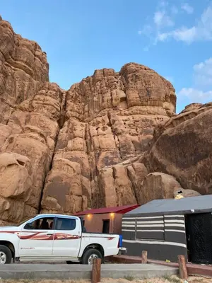a white truck parked in front of a mountain at Camp safaa rum in Wadi Rum