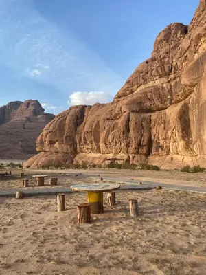 a group of benches in the desert with a mountain at Camp safaa rum in Wadi Rum